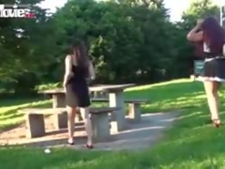 Dva lesbičky casually blesk jejich kundičky v a veřejné park